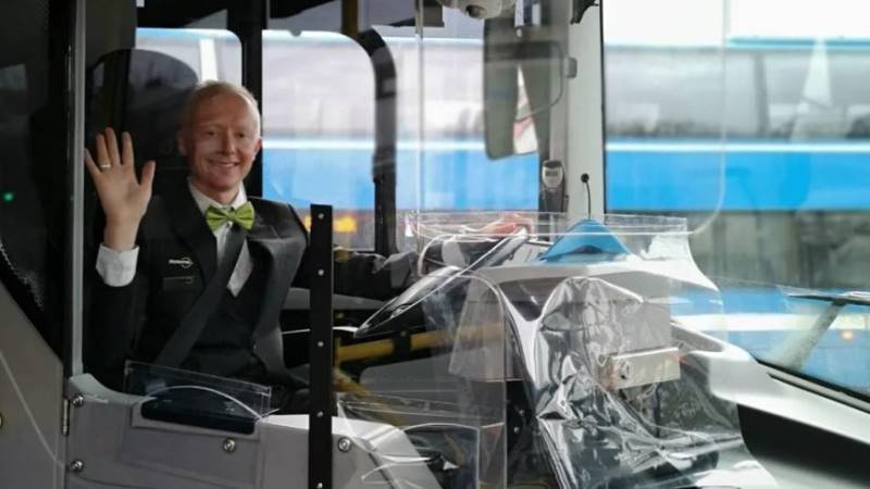 Busschaufför vid förarsätet, runt omkring sig ett plexiglasskydd