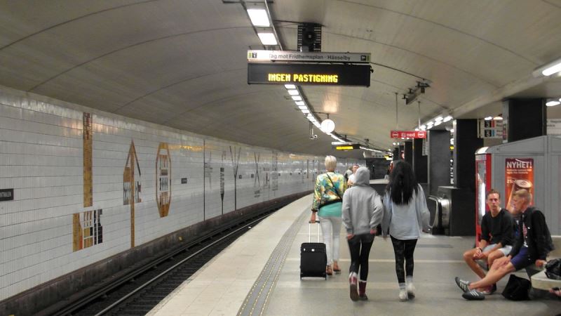 Tunnelbaneplattformen T-centralen. Inomhus, en perrong med människor som går där.