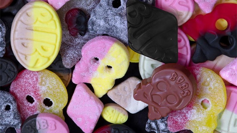 Bild på lösgodis, flera sega skumfigurer i form av döskallar och elipser. I gult, svart rött och rosa.