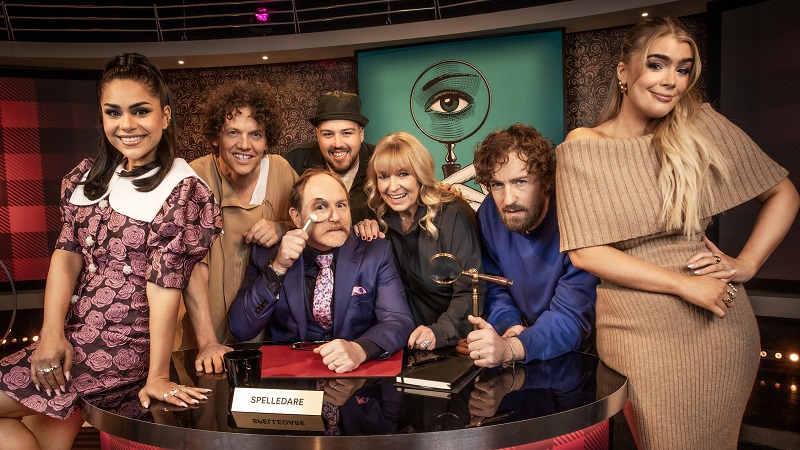 Runt ett skrivbord med förstoringsglas står de medverkande i Detektiverna som är Arantxa Alvarez, Nassim Al Fakir, Morgan Alling, Anis Don Demina, Sussie Eriksson, Nisse Hallberg och Kristina ”Keyyo” Petrushina.