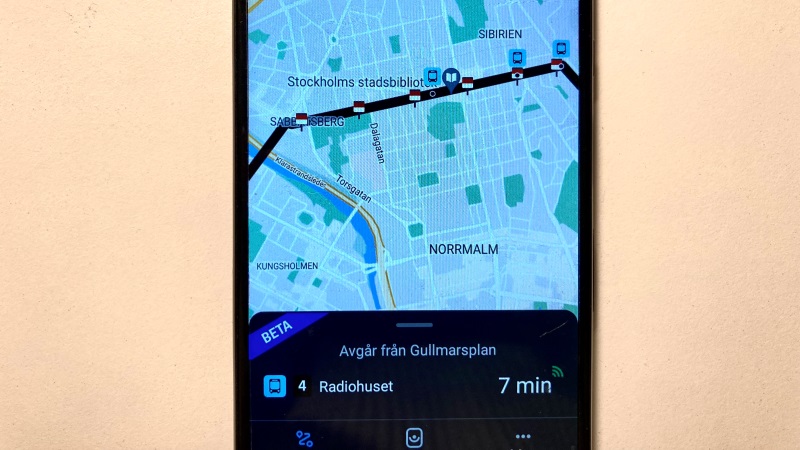 Mobil med en stadskarta på displayen, en streckad busslinje.