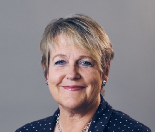 Désirée Pethrus. Kvinna med kort, ljust hår. Svart kavaj med vita prickar.